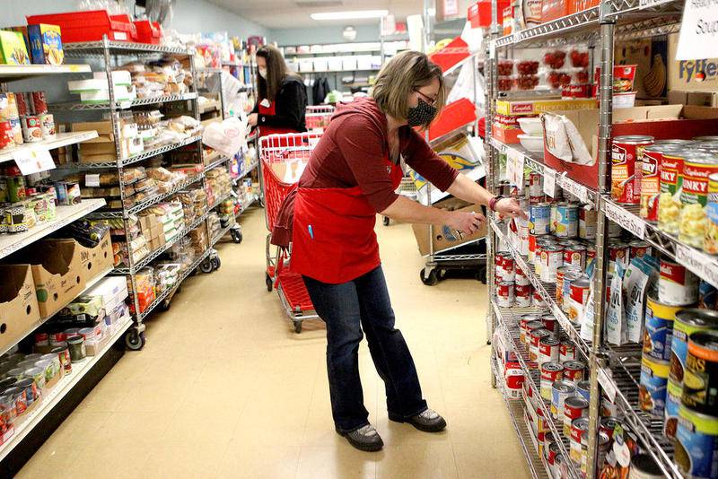 Eileen Pasero, executive director of the Batavia Interfaith Food Pantry and Clothes Closet, gathers non-perishable items for a client's monthly pick-up at the Batavia Interfaith Food Pantry.