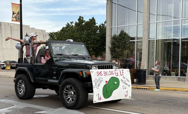 A member of the Streator High School golf team tosses a rubber golf ball from the team’s jeep during the school’s homecoming parade Wednesday, Oct. 1, 2025, in Streator.