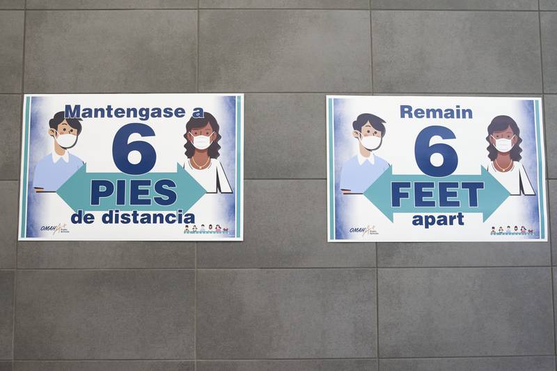 FILE - Signs on the wall remind students to keep 6 feet apart during a media tour of the Norris Middle School in Omaha, Neb., Wednesday, July 29, 2020. The CDC has again revised its COVID guidelines, further relaxing quarantine recommendations and dropping the recommendation that people stay at least 6 feet away from each other. (AP Photo/Nati Harnik, File)