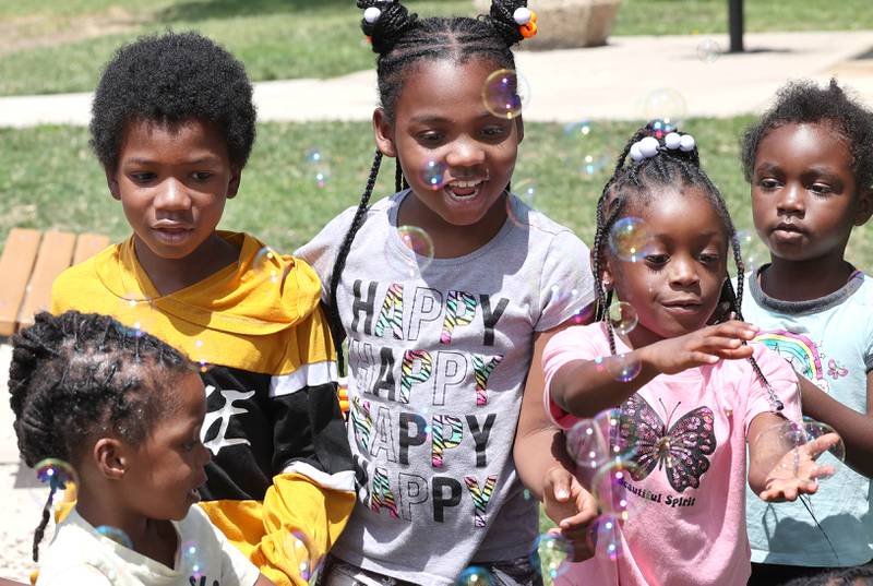 Kids play with bubbles Tuesday, July 18, 2023, during Camp Power at Welsh Park in DeKalb. Camp Power, which is run by the Kishwaukee Valley YMCA, is a summer program for youth at University Village that provides positive activities for kids.