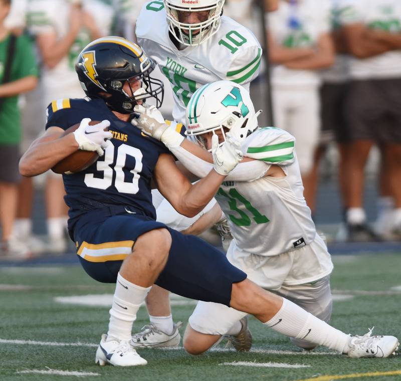 Joe Lewnard/jlewnard@dailyherald.com
Glenbrook South's Dom Reikiewicz, left, gets tackled by York’s Charlie Georgas on a play on which a facemask penalty was called during a football game played in Glenview, Ill. on Friday, Aug. 25, 2023.