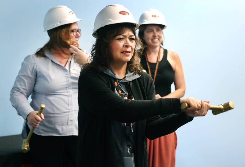 DeKalb School District 428 Superintendent Minerva Garcia-Sanchez gets loose before taking a ceremonial swing into the drywall Friday, Aug. 9, 2024, during the Beyond One Barb Transition Center Construction Kick-Off event at the new site at 530 Charter St. in DeKalb.