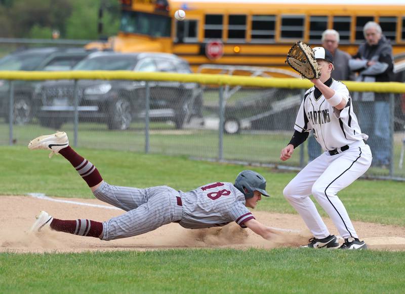 Morris' Quaid Phillips dives back into first safely as Sycamore's Noah Neece waits for the throw Wednesday, May 13, 2026, during their game at the Sycamore Community Sports Complex.
