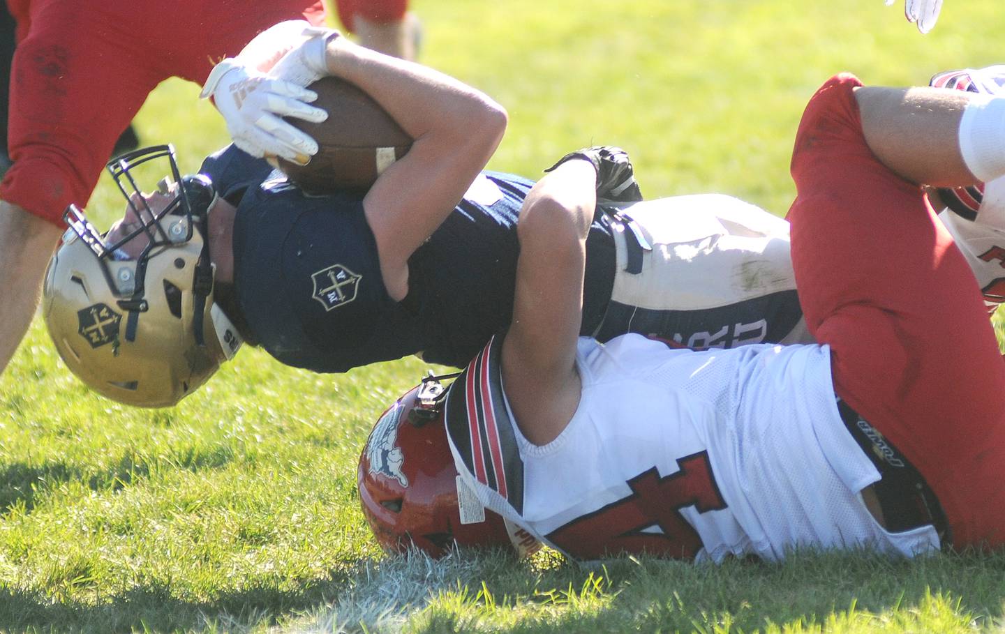 Marquette's Tom Durdan is tackled by Fulton's Joey Hulzenga in the 1A playoff game at Gould Stadium on Saturday, Nov. 6, 2021.