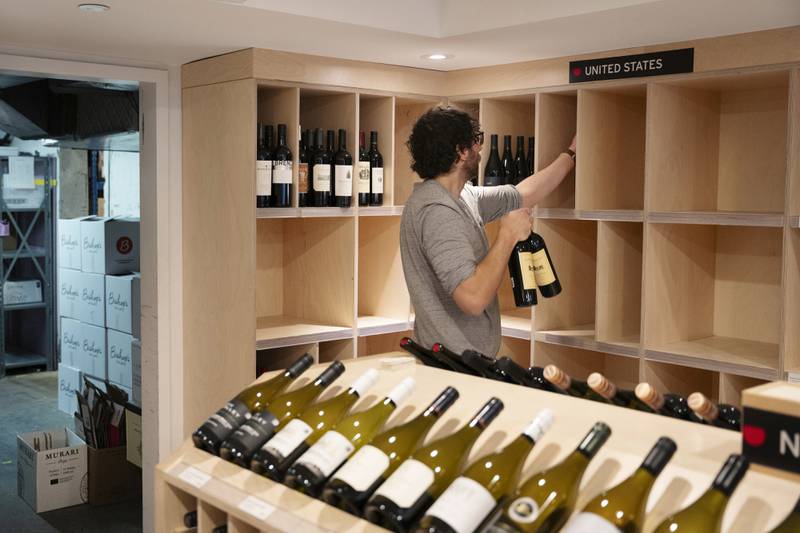 An employee removes American-made wine from their shelves at Bishop's Cellar in Halifax on Wednesday, March 5, 2025. (Darren Calabrese /The Canadian Press via AP)