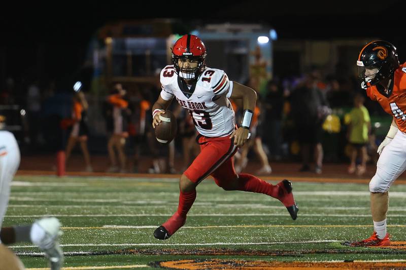 Bolingbrook’s Jonas Williams rolls out of the pocket against Lincoln-Way West on Friday, Sept. 22 in New Lenox.