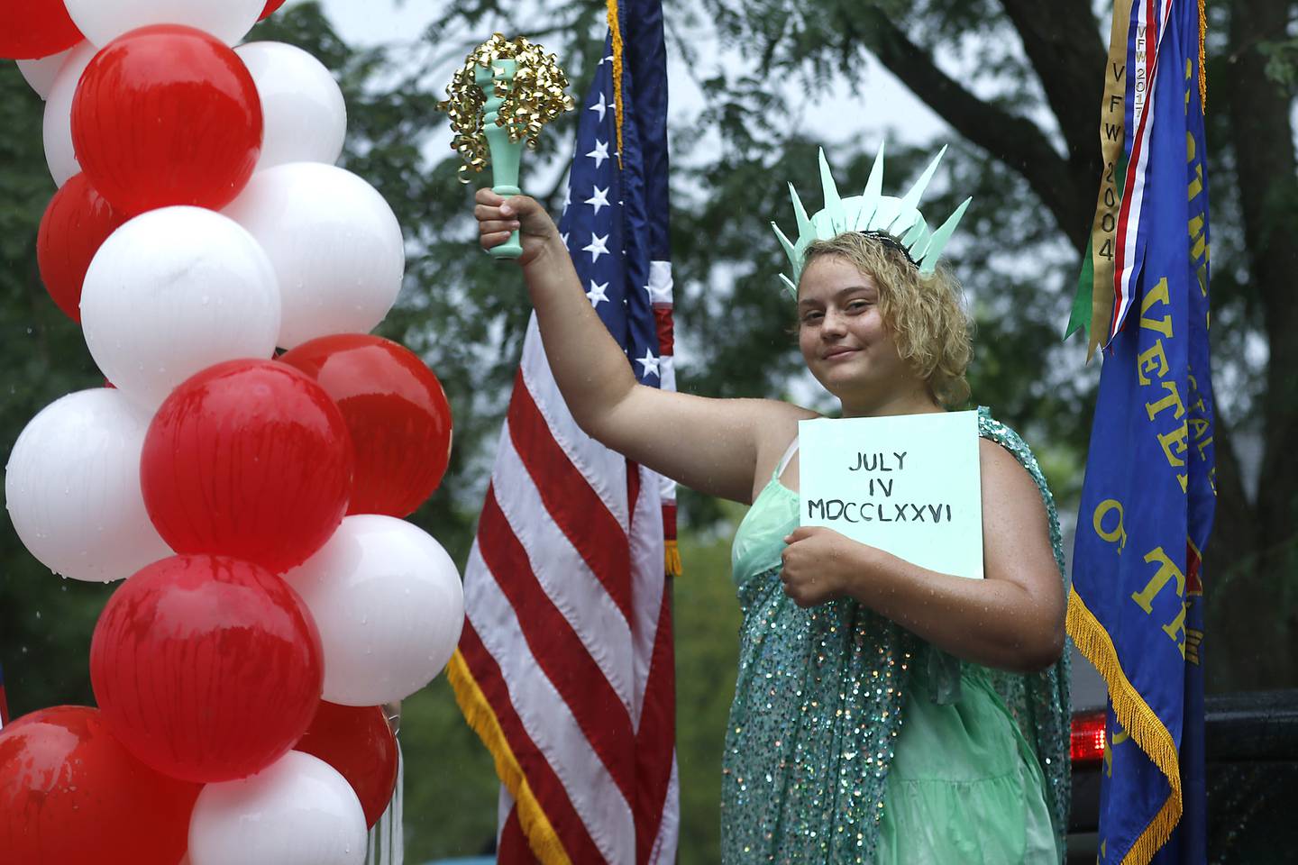 A girl dressed as the Statue of Liberty rides on the Crystal Lake Memorial VFW Post 12014 float on Sunday, July 7, 2024, during Crystal Lake’s annual Independence Day Parade on Dole Avenue in Crystal Lake. This year’s parade feature close to 100 units. I like this image because of the way the girl is framed between the balloons and flags.