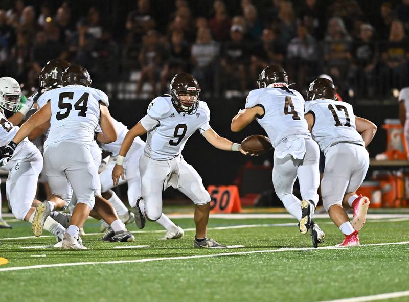 Joliet Catholic's Tj Schlageter (9) hands the ball off to Brett Mouw on Friday, Sep 16, 2022, at New Lenox.