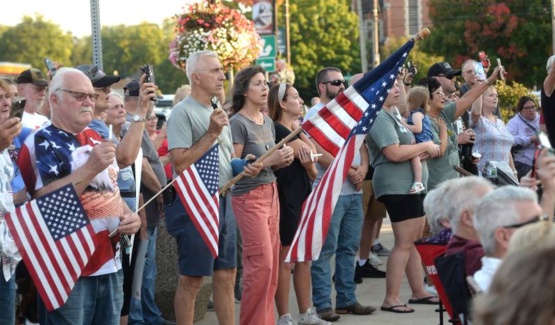People sing as they hold their candles or cell phone  lights during a vigil for Charlie Kirk on Sunday, Sept. 14, 2025 in Oregon. An estimated crowd of 300-350 attended the hour-long evening event.