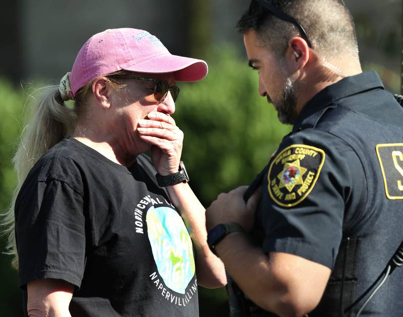 Molly Swick, is greeted by a DeKalb County sheriff’s deputy as she arrives on the scene Tuesday, Sept. 30, 2025, in front of a house in the 1300 block of Oakland Drive in Sycamore where two people were found dead Tuesday morning.