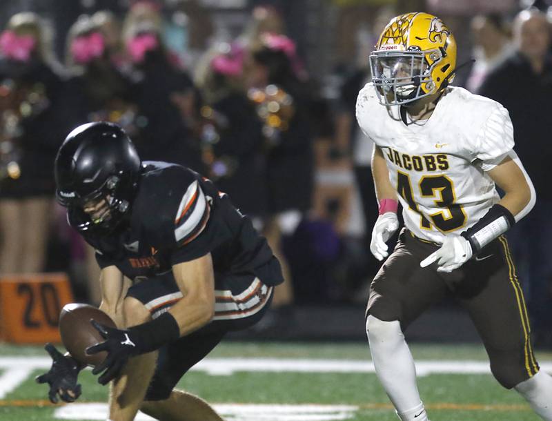 McHenry's Owen Hobson catches a tipped pass in front of Jacobs' Brandon Chvatal  during a Fox Valley Conference football game on Friday, Oct. 18, 2024, at McCracken Field in McHenry.