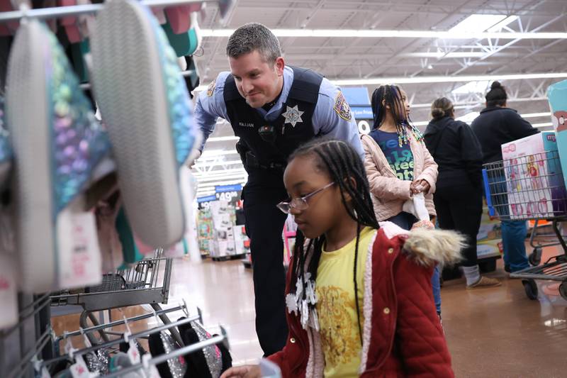 Officer Casey Killain helps Autumn pick out slippers at the annual Santa Cop at Walmart in Joliet.