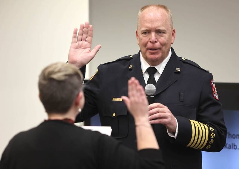 Acting DeKalb Fire Chief Michael Thomas is sworn in by Ruth Scott, DeKalb City Council recording secretary, as the city's new full-time fire chief Monday, April 11, 2022, during the council meeting at the library. Thomas has been serving as the acting chief since the retirement of former chief Jeff McMaster in November.