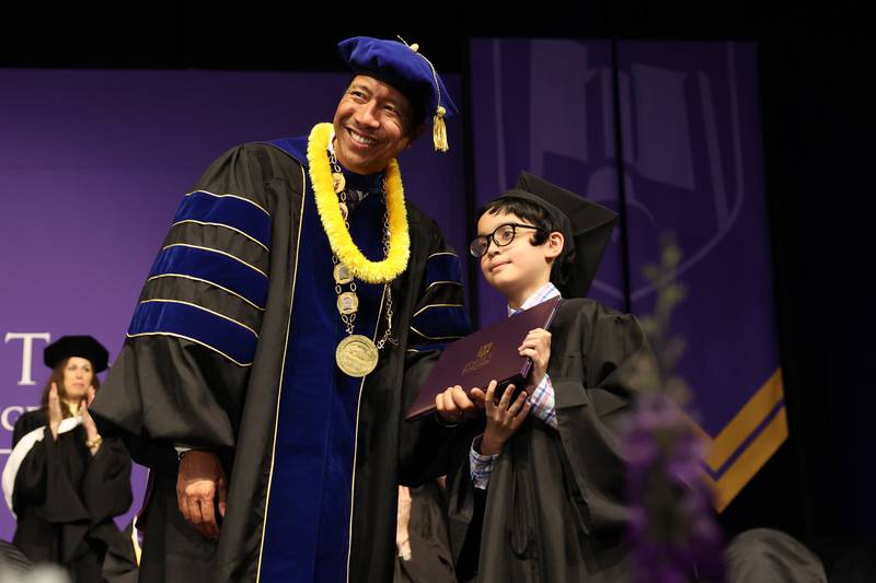 President Dr. Clyne Namuo poses with Benjamin Bamburc after receiving his Associate in Arts Degree at the Joliet Junior College Commencement Ceremony on Friday, May 19, 2023, in Joliet.