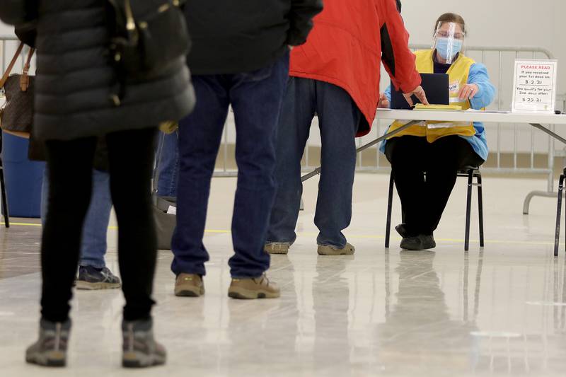A worker checks in people with appointments during a COVID-19 vaccination clinic through the McHenry County Department of Health at 1900 N. Richmond Rd, the former site of a KMart, on Tuesday, March 2, 2021 in McHenry.  Vaccinations are made by appointment only.