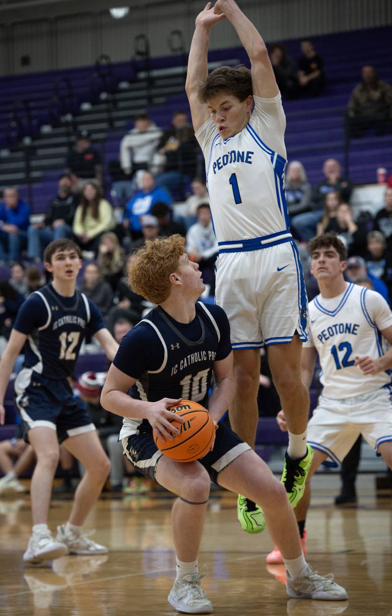 IC Catholic's Will Schmidt, left, looks for an open shot as Peotone's Alex Chenoweth, right, defends in the Thanksgiving tournament at Manteno High School on Monday, November 24, 2025.