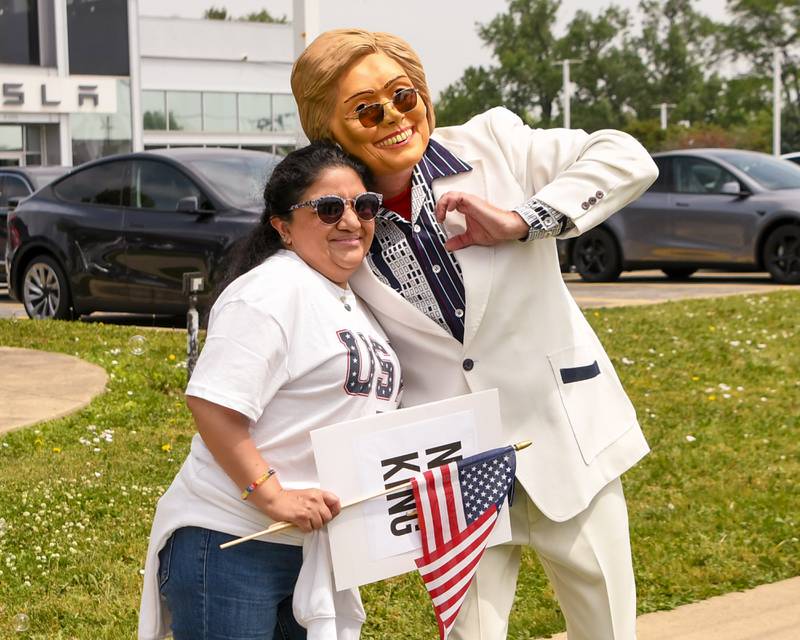 Cinthya Valdez of Aurora is all smiles as she poses for a photo with someone dressed as Hillary Cliton during the No Kings rally on Saturday June 14, 2025, held near the Tesla dealership on Ogden Ave. in Lisle.
