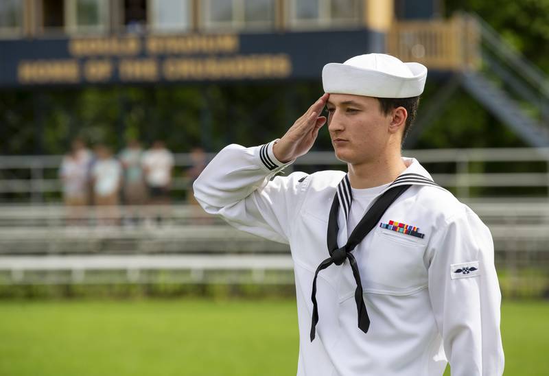Austin Howard, an Ottawa High School graduate from the class of 2020, presents the flag Sunday, May 29, 2022, at his sister's graduation at Gould Stadium.