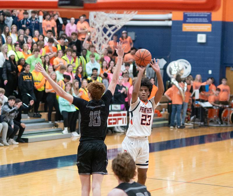 Oswego’s Dasean Patton (23) shoots a three pointer against Oswego East's Noah Mason (10) during a basketball game at Oswego High School on Tuesday, Dec 12, 2023.