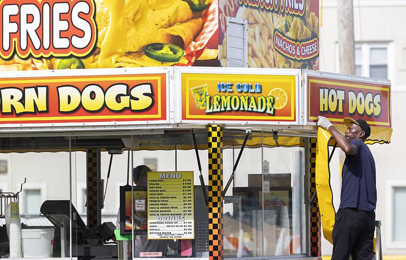 Donald Lloyd puts the finishing touches on a vendor Monday, July 1, 2024 at the Petunia Fest carnival in Dixon. The fest kicks off Wednesday.