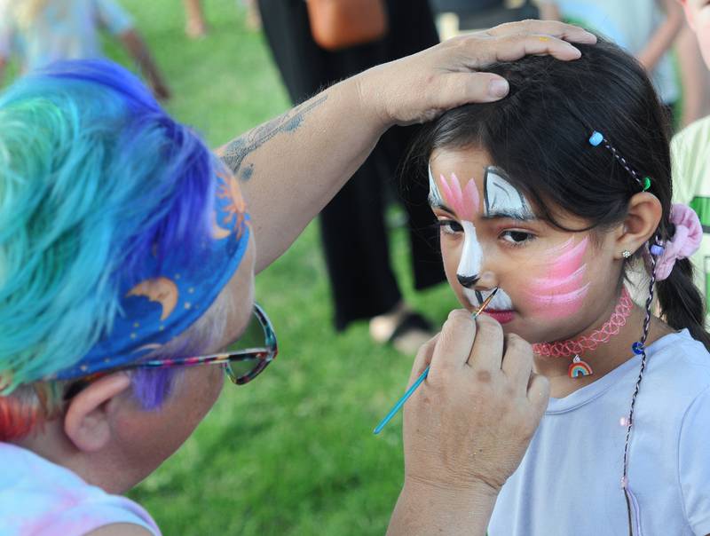 Romina Landeros gets her face painted by Crazy Cat Lady Face Painting Tuesday evening at Peck Park in Ottawa during National Night Out. Numerous games and family activities took place during the three hour event.