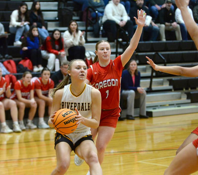 Riverdale's Cayleigh Hungate (21) drives to the basket as Oregon's Madison Shaffer (1) defends at the 2A Erie-Prophetstown Regional on Thursday, Feb. 20, 2025.