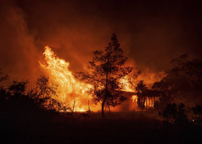 FILE - A structure is engulfed in flames as a wildfire called the Highland Fire burns in Aguanga, Calif., Oct. 30, 2023. Revved-up climate change now permeates Americans’ daily lives with harm that is “already far-reaching and worsening across every region of the United States," a massive new government report says Tuesday, Nov. 14. (AP Photo/Ethan Swope, File)