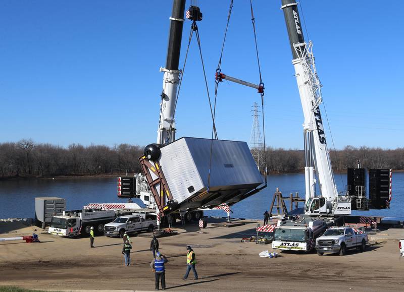 A crew from Atlas Crane Services hoist a 300,000 pound boiler made by the Cleaver-Brooks company in Lincoln Neb. on Wednesday Dec. 13, 2023 at Marquis Energy in Hennepin.. The boiler was transported by barge to to Hennepin from Nebraska using the Missouri River, Mississippi River and Illinois River. Marquis Energy is expected to receive several boilers within the next 12 months.