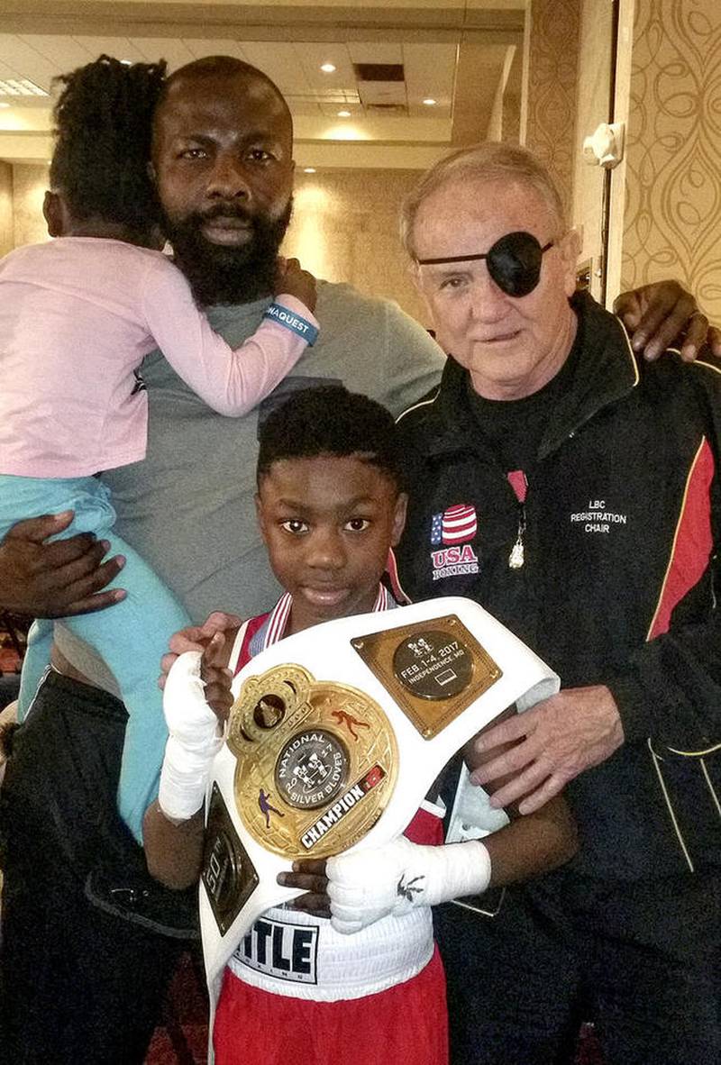 Joseph "Jo Jo" Awinongya – flanked by his father, Joseph, and John Brown, president of USA Boxing – displays his championship belt after he won the 8-9-year-old, 80-pound division at the Silver Gloves Nationals in Independence, Missouri.