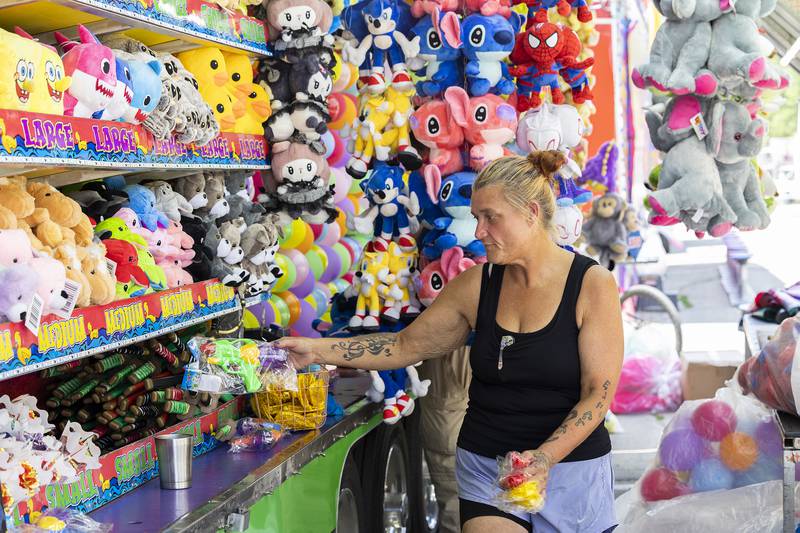 Tiffany Mitchell organizes prizes Tuesday, July 1, 2025, while setting up for Dixon’s Petunia Fest carnival.