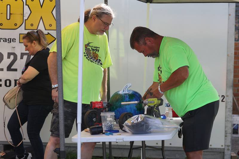 Jeff Geobel, left, and Mike Hilbert put wheels on an pumpkin entry for the Pumpkin Derby at the Wish Upon a Star fundraiser on Saturday, Oct. 5, 2024 in Joliet.