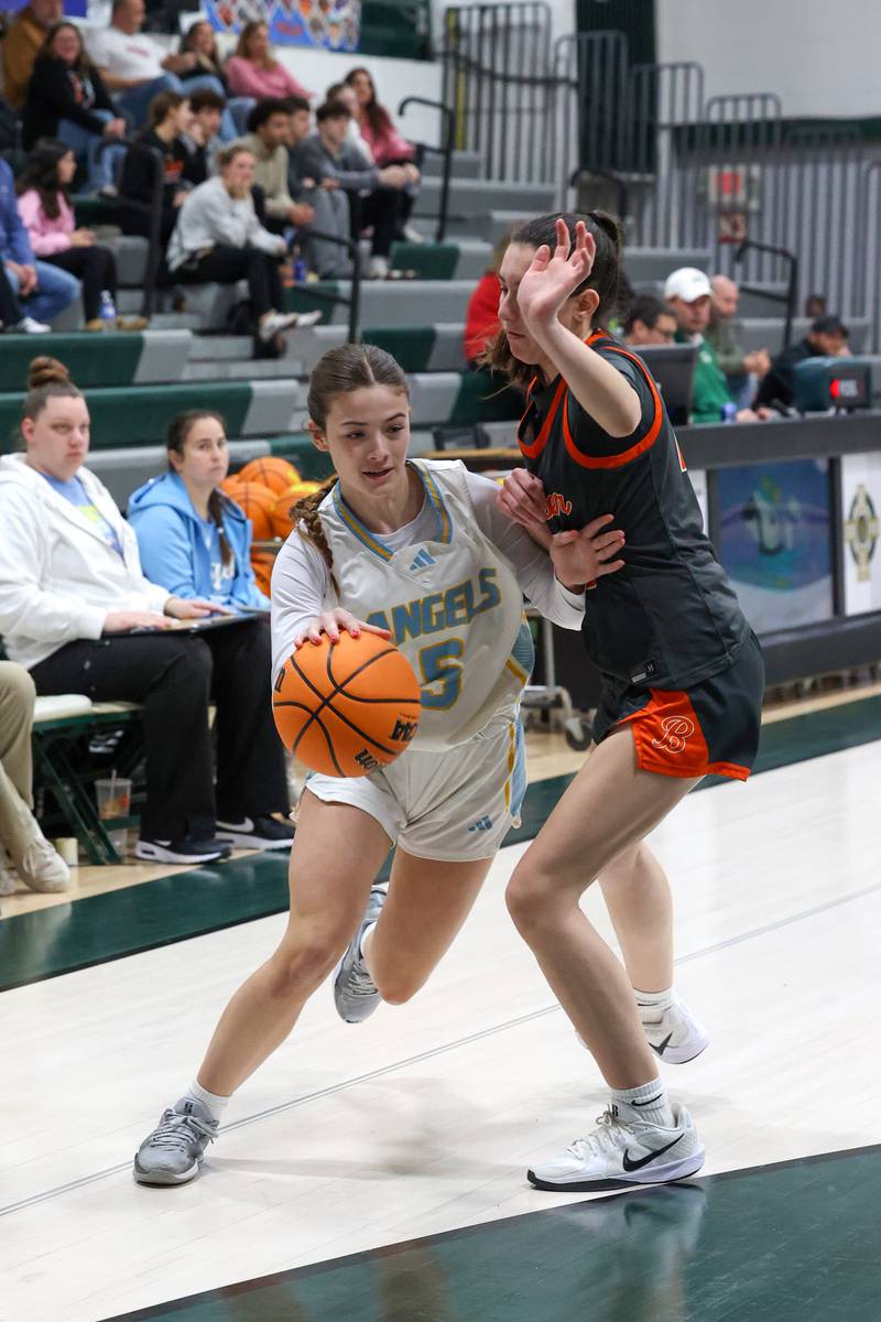 Joliet Catholic's Callan Kinsella drives to the lane against Beecher's Kaylee Kopec during Joliet Catholic's 72-28 victory over Beecher in the IHSA Class 2A Bishop McNamara Regional semifinals on Monday, Feb. 16, 2026.