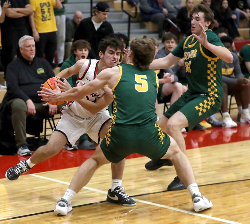Huntley's Casey Kaczmarski (left) tries to get out of the double team by Crystal Lake South's Carson Trivellini (center) and Ryan Morgan (right) during a Fox Valley Conference boys basketball game on Wednesday, Dec. 10, 2025, at Huntley High School.