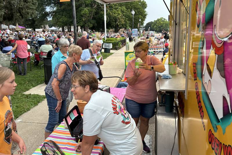With temperatures in the 90s, the Just 4 Fun ice cream truck was very popular at the Jamboree concert on Friday, Aug. 15, 2025 in downtown Mt. Morris. Here, Janice Deets serves up a dish of ice cream as Nancy Tegeler takes an order.