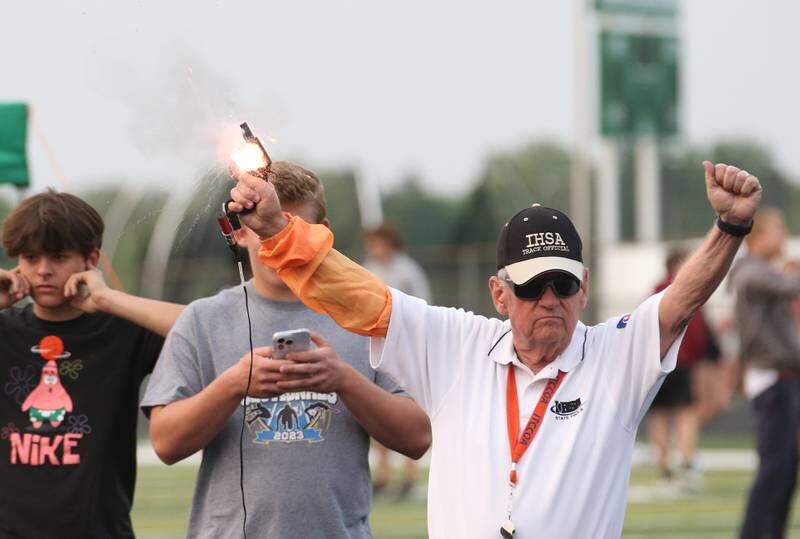 An IHSA track official fires the starting gun during the Class 2A track sectional meet on Wednesday, May 17, 2023 at Geneseo High School.