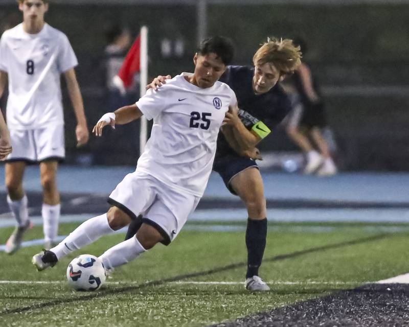 Downers Grove North's Jose Duran (25) fights off the defense during soccer match between Downers Grove North at Downers Grove South. Oct 2, 2025.