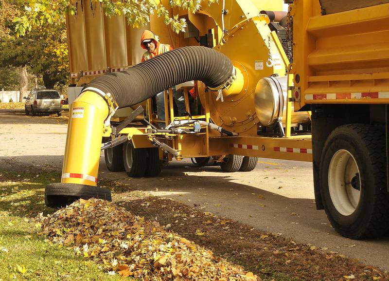 Matt Kimmey of the Sandwich Public Works Department uses a vacuum machine to pick up leaves a resident had raked to the side of the street.