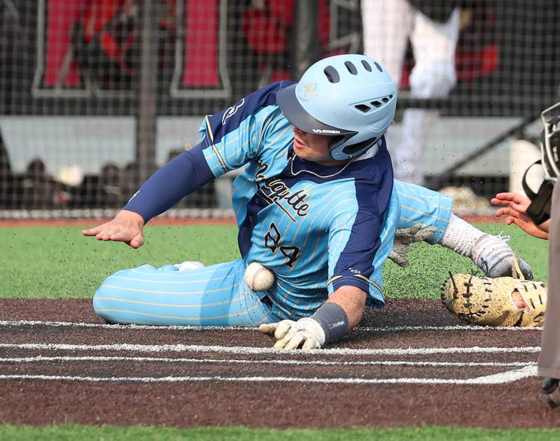 Marquette's Anthony Couch is hit in the stomach by the throw home allowing him to score a run Monday, June 2, 2025, during their Class 1A supersectional game against Fulton at Northern Illinois University in DeKalb.