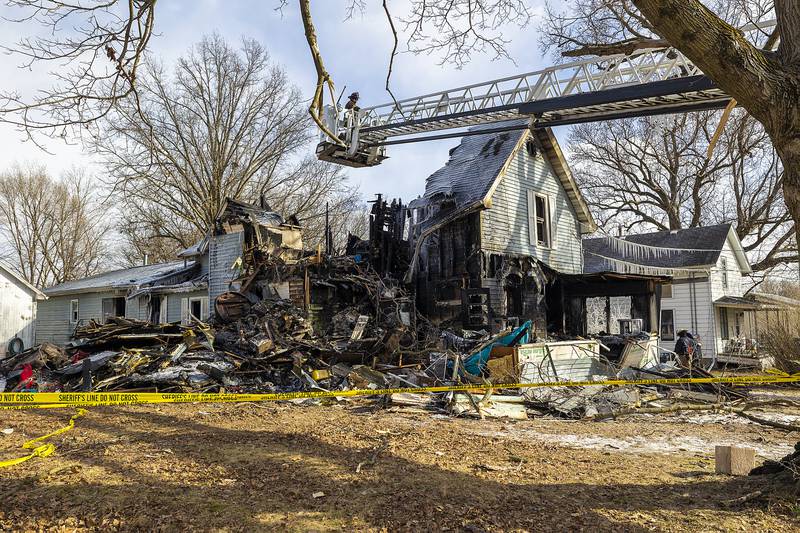 Investigators work at the scene of a house fire Monday, Jan. 20, 2025, in Sterling. Firefighters are still searching for a possible victim of the blaze.
