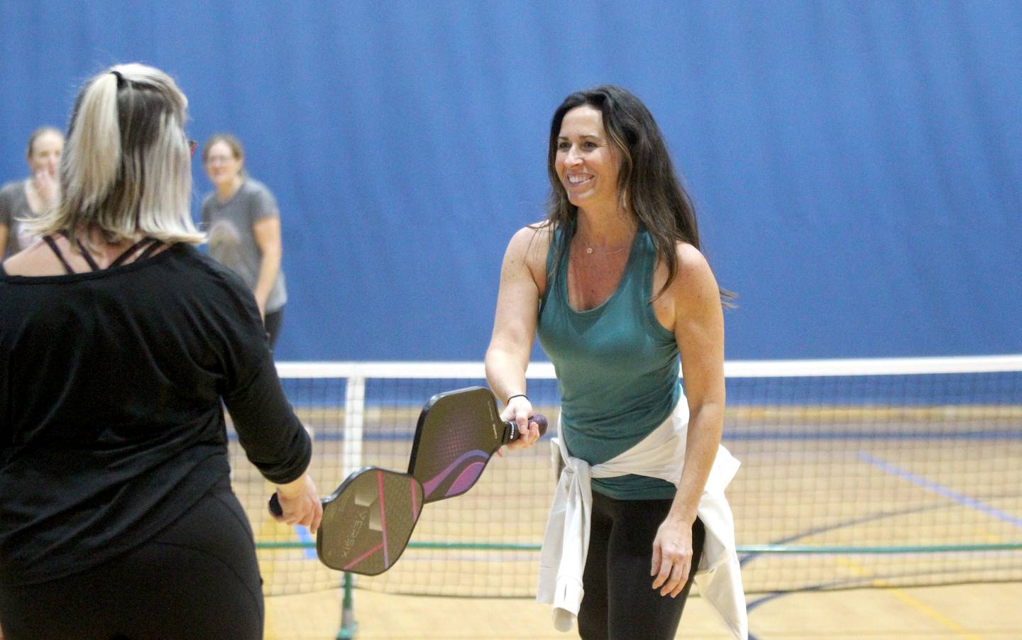 Joanna McKay of St. Charles touches paddles with her doubles partner during a pickle ball open gym session at the Stephen D. Persinger Recreation Center in Geneva on Jan. 12, 2023.
