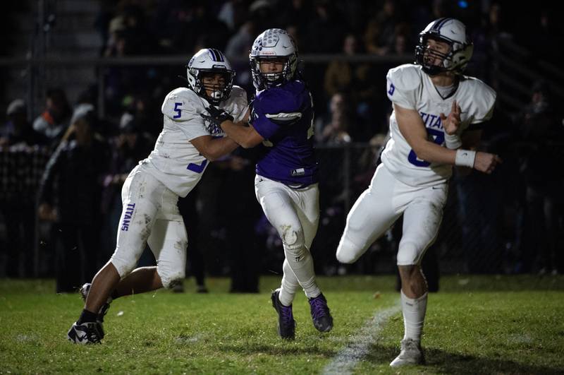 Wilmington's Hunter Kaitschuk, center, is held back by El Paso-Gridley's Aaden Adams, left, as he tries to reach quarterback Owen Adams, right, in the Class 2A semifinal on Saturday, November 22, 2025.