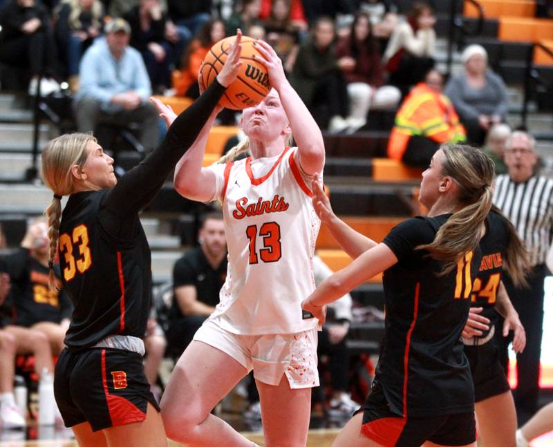 St. Charles East’s Addie Schilb tries to get a shot past Batavia’s Natalie Warner (left) and Kaidyn King (right) during a game on Wednesday, Jan. 8, 2025 in St. Charles.