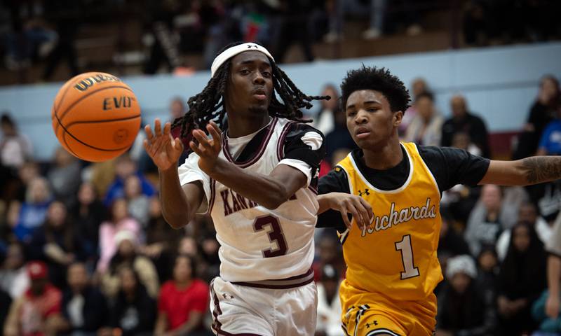 Kankakee's Cedric Terrell III, left, makes a pass as Richards's Sammy Childs, right, guards in a game in the Kankakee Holiday Tournament at Kankakee High School on Saturday, December 27, 2025.