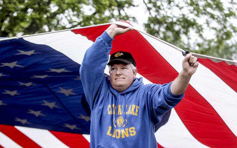 Dave Janquart of Crystal Lake helps the Crystal Lake Lions Club carry an American flag Monday during the Crystal Lake Memorial Day Parade.
