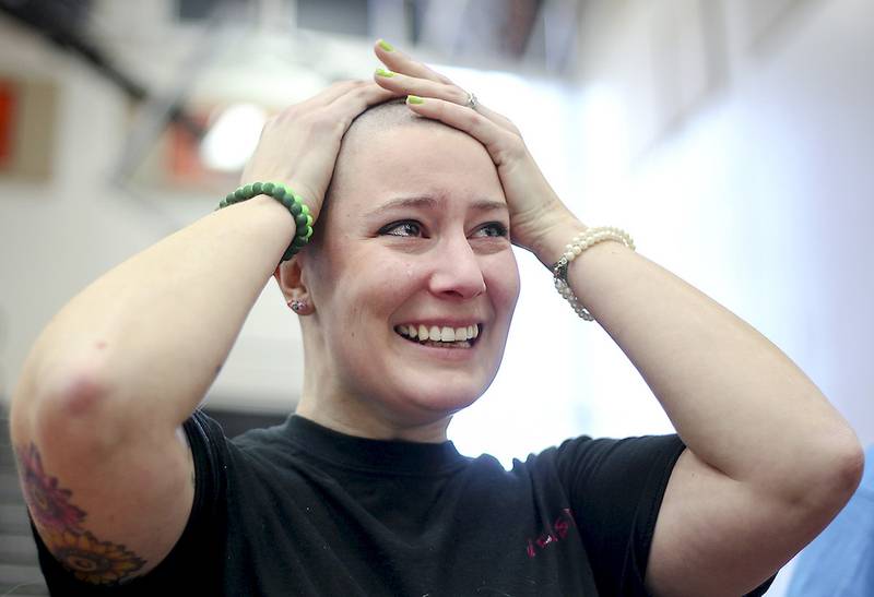 Jessica Rogers of McHenry rubs her fingers over her newly shaved head Thursday after participating in the annual St. Baldrick's Foundation's community shave sponsored by McHenry High School in McHenry. Rogers raised $1,265 for childhood cancer research.