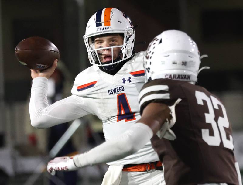 Oswego's Drew Kleinhans passes the ball around Mount Carmel's Roman Igwebuike Wednesday, Dec. 3, 2025, during their IHSA Class 8A state chamionship game in Huskie Stadium at Northern Illinois University in DeKalb.
