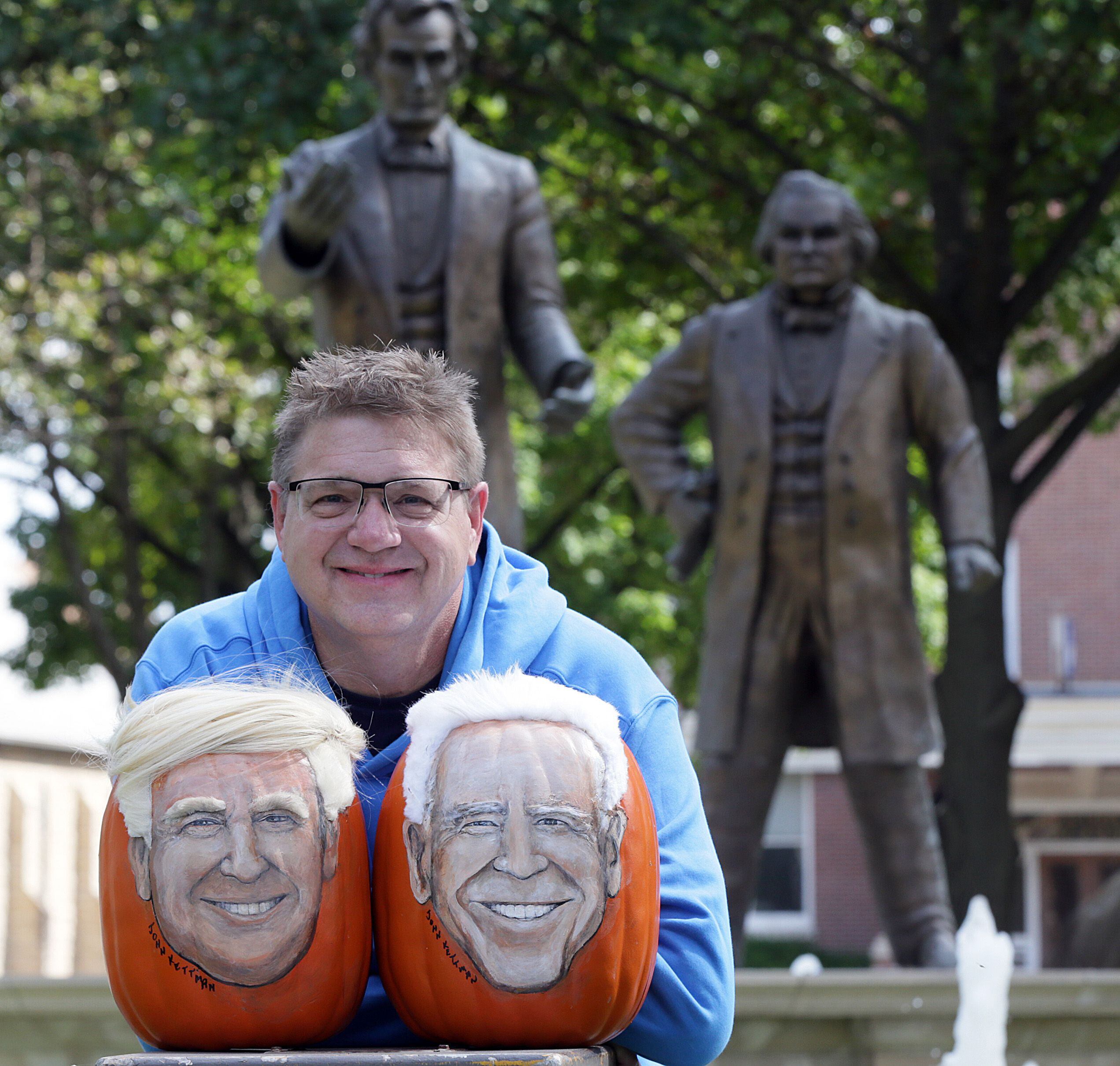 Artist John Kettman poses with political pumpkins created for Donald Trump and Joe Biden during the 2020 election.