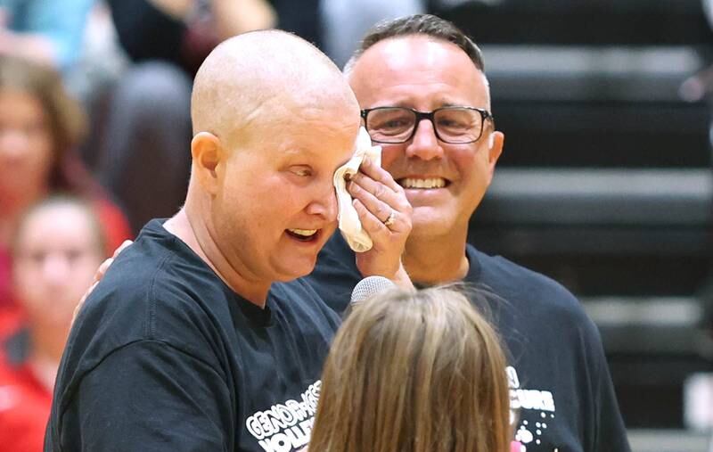 Becky Cleveland and her husband David become emotional as they are recognized as the guests of honor before the Genoa- Kingston volleyball team's Volley for the Cure breast cancer fundraiser match against Oregon Wednesday, Sept. 21, 2022, at Genoa-Kingston High School. Cleveland, a former student and teacher at Genoa-Kingston High School is currently battling cancer.