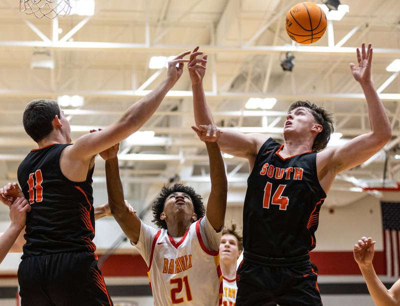 From left: Wheaton Warrenville South’s Zach Rogers, Batavia’s Xavier Justice and Wheaton Warrenville South’s Sean Doherty go up for a rebound during a game at Batavia High School on Tuesday, Jan. 7, 2025.