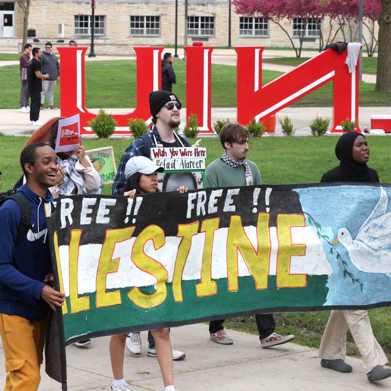 A group of about twenty demonstrators chant slogans as they march past the NIU sculpture at Northern Illinois University in DeKalb Monday, April 29, 2024, to protest the Israel-Hamas War.